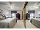 Spacious bedroom with two comfortable beds, mirrored closet, and dark wood dressers with soft lighting at 283 Yank Ct, Lakewood, CO 80228