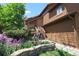 Charming brown home with well-manicured flowerbeds and stone retaining wall leading to front steps at 283 Yank Ct, Lakewood, CO 80228