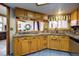 Kitchen featuring wood cabinets, tile countertops, and views of the dining room at 283 Yank Ct, Lakewood, CO 80228