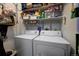 Functional laundry room with washer, dryer, and shelving providing ample storage space at 283 Yank Ct, Lakewood, CO 80228