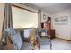 Bright sitting area featuring two chairs, a large window with a textured screen, and classic wood furniture at 283 Yank Ct, Lakewood, CO 80228