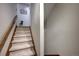 Carpeted staircase with wooden handrail and a charming dog posing near the top at 283 Yank Ct, Lakewood, CO 80228