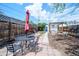 Fenced backyard featuring a table set with umbrella, brick patio, and path to a detached building at 4467 W 30Th Ave, Denver, CO 80212
