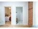 Hallway with bedroom and closet entrances, brick accent wall and hardwood floors at 4467 W 30Th Ave, Denver, CO 80212