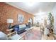 Comfortable living area featuring exposed brick, a plush sofa, decorative rug, and adjoining dining space at 4467 W 30Th Ave, Denver, CO 80212