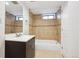 Bathroom featuring tiled walls, a vanity, and a shower over bathtub with window at 2285 Fulton St, Aurora, CO 80010