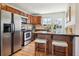 Well-equipped kitchen with stainless steel appliances, granite countertops, and breakfast bar seating at 2285 Fulton St, Aurora, CO 80010