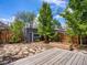 Charming backyard with stone pathway, wood deck, garden, and shed, a private retreat for relaxing or entertaining at 1423 Elizabeth St, Denver, CO 80206