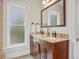 Bright bathroom with double sinks, granite countertop vanity, and large trimmed windows at 1423 Elizabeth St, Denver, CO 80206