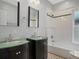 Updated bathroom featuring modern fixtures, double sinks, and a tiled tub and shower at 1423 Elizabeth St, Denver, CO 80206