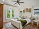 Bright bedroom features a ceiling fan, large windows, and hardwood floors with area rug at 1423 Elizabeth St, Denver, CO 80206