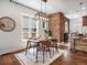 Stylish dining room with a modern chandelier, brick wall, and seating for four, ideal for intimate dinners at 1423 Elizabeth St, Denver, CO 80206
