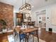 The dining room has an exposed brick wall and views into the kitchen and sitting room at 1423 Elizabeth St, Denver, CO 80206