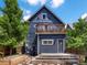 Blue house exterior featuring a wood deck, stone pathway, and lush trees, blending modern design with natural charm at 1423 Elizabeth St, Denver, CO 80206