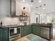 Renovated kitchen featuring stainless steel appliances, breakfast bar, floating shelves and modern lighting at 1423 Elizabeth St, Denver, CO 80206