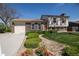 Charming brick and siding two-story home with a well-manicured lawn, flower bed, and attached garage at 1838 Cedar St, Broomfield, CO 80020