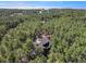 An aerial shot of a house beautifully integrated into a dense forest, creating a serene and secluded environment at 17940 Smugglers Rd, Monument, CO 80132
