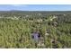 Expansive aerial view showcasing a home surrounded by a dense forest, offering privacy and natural beauty at 17940 Smugglers Rd, Monument, CO 80132