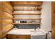 A cozy bar area with custom wood shelving, a farmhouse sink and unique tile backsplash at 17940 Smugglers Rd, Monument, CO 80132