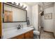 Bright bathroom with wood vanity, quartz countertops, and an adjacent shower at 17940 Smugglers Rd, Monument, CO 80132