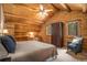 Charming log cabin bedroom featuring wood ceiling, built in desk, and sitting chair at 17940 Smugglers Rd, Monument, CO 80132