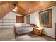 Bedroom featuring angled wood ceiling, a window with a forest view and a wooden nightstand at 17940 Smugglers Rd, Monument, CO 80132
