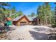 Log home with attached garage and a separate storage shed in a wooded area at 17940 Smugglers Rd, Monument, CO 80132
