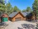 Exterior view of a beautiful log cabin home with a detached garage at 17940 Smugglers Rd, Monument, CO 80132