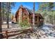 Charming log home with brick chimney and covered porch nestled among trees at 17940 Smugglers Rd, Monument, CO 80132