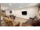 Basement living room with stairs, wall-mounted TV, and plush seating at 17940 Smugglers Rd, Monument, CO 80132