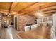 Open living room with a brick wall, wood burning stove and access to the kitchen and staircase at 17940 Smugglers Rd, Monument, CO 80132