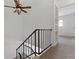 Open hallway with carpeted floors, ceiling fan and iron railing on staircase at 8678 Mariposa St, Thornton, CO 80260