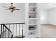 Bright hallway featuring built-in shelving, carpeted floors, and modern ceiling fan at 8678 Mariposa St, Thornton, CO 80260