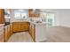Spacious kitchen featuring wooden cabinets, a cooktop island, and hardwood floors at 8678 Mariposa St, Thornton, CO 80260
