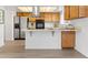 Bright kitchen featuring stainless steel appliances, wooden cabinetry, and an island cooktop at 8678 Mariposa St, Thornton, CO 80260