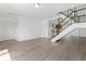 Open-concept space with hardwood floors, a staircase, and a glimpse of the kitchen at 8678 Mariposa St, Thornton, CO 80260