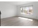 Sunlit living room featuring wood floors, a large window, and neutral-toned walls at 8678 Mariposa St, Thornton, CO 80260