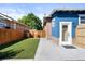 A well-maintained backyard featuring manicured grass, a concrete pathway, and a classic brick and siding home exterior at 1534 Meade St, Denver, CO 80204