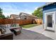 A landscaped backyard features an outdoor sectional sofa, modern coffee table, and manicured lawn by the house at 1534 Meade St, Denver, CO 80204