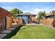 A fenced backyard with artificial turf, concrete patio, and outdoor dining set, perfect for entertaining and relaxing at 1534 Meade St, Denver, CO 80204
