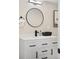 Contemporary bathroom vanity featuring a round mirror, white countertop, and matte black fixtures at 1534 Meade St, Denver, CO 80204
