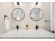 Elegant bathroom with double sinks, marble countertops, and round mirrors at 1534 Meade St, Denver, CO 80204