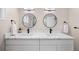 A modern bathroom boasts a double vanity, quartz countertops, contemporary lighting, and round mirrors at 1534 Meade St, Denver, CO 80204