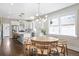 Open dining area with a round wooden table, modern chandelier, and seamlessly connected to the kitchen space at 1534 Meade St, Denver, CO 80204