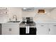 Charming kitchen featuring stainless steel appliances, a sleek cooktop, quartz countertop, and white cabinetry at 1534 Meade St, Denver, CO 80204