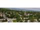 Expansive aerial view of a serene neighborhood near a lake, surrounded by lush greenery and distant mountains at 8595 Field Ct, Arvada, CO 80005