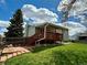 The backyard has a wooden deck, a lawn, a wooden fence and convenient access to the interior at 8595 Field Ct, Arvada, CO 80005