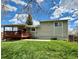 A view of the backyard with a well-manicured lawn, a deck, and the home's exterior at 8595 Field Ct, Arvada, CO 80005
