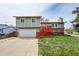 Charming two-story home with an attached garage, red stairs, and well-maintained yard at 8595 Field Ct, Arvada, CO 80005
