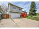 A charming two-story home features an attached garage, and vibrant red front steps at 8595 Field Ct, Arvada, CO 80005